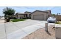 Spacious home featuring an extra-long driveway, desert landscaping, and a well-maintained lawn at 14703 W Hillside St, Goodyear, AZ 85395