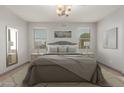 Inviting bedroom with soft gray accents, a large mirror, and bright windows at 16229 W Jenan Dr, Surprise, AZ 85379