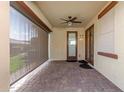 Covered outdoor patio with a ceiling fan and shade screen, perfect for relaxing and entertaining guests at 16229 W Jenan Dr, Surprise, AZ 85379