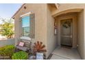 Inviting entryway with charming decor, including a welcome mat, rustic windmill, and a quaint bench at 17971 W Meadowbrook Ave, Goodyear, AZ 85395