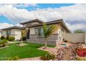 Stunning single-story home with desert landscaping, synthetic lawn, and stone accents at 18134 W Highland Ave, Goodyear, AZ 85395