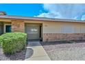 Inviting front entrance with brick accents, manicured bushes, and a well-lit walkway at 18610 N Mica Dr, Sun City West, AZ 85375