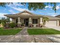 Charming single-story home featuring a landscaped front yard, covered porch, and two-car garage at 19203 S 185Th Dr, Queen Creek, AZ 85142