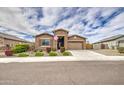 Inviting home with a stone entrance, beautiful shrubs, and a well-maintained lawn at 19742 W Harrison St, Buckeye, AZ 85326
