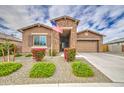 Beautiful home showcasing a stone entryway, well-kept lawn, and a welcoming facade at 19742 W Harrison St, Buckeye, AZ 85326