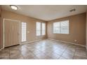 Inviting living room featuring tile floors, neutral paint, and multiple windows providing natural light at 21549 N Backus Dr, Maricopa, AZ 85138