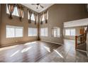 Spacious living room features soaring ceilings, wood floors, and an open concept design at 21549 N Backus Dr, Maricopa, AZ 85138