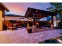 Outdoor patio with pergola, fire pit, desert landscaping, and view of the pool at 2361 N 156Th Dr, Goodyear, AZ 85395
