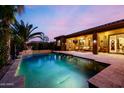 Beautiful pool and patio with lush landscaping and a covered seating area at 2361 N 156Th Dr, Goodyear, AZ 85395