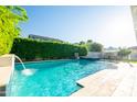 An inviting swimming pool with stone tile, cascading water feature, and verdant foliage, perfect for relaxation at 2973 E Austin Dr, Gilbert, AZ 85296