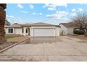 Ranch-style home featuring a large driveway, two-car garage, and desert landscaping at 3026 E Bremen St, Phoenix, AZ 85032