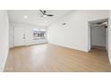 Spacious living room with sleek ceiling fan, light hardwood floors, and a large window at 3026 E Bremen St, Phoenix, AZ 85032