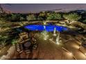 Desert home's beautiful stone patio boasts a fireplace and comfortable seating around a pool at 30330 N 77Th Pl, Scottsdale, AZ 85266