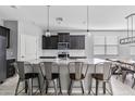 Modern kitchen featuring a large island, stainless steel appliances, and dark cabinetry at 4087 W Coneflower Ln, San Tan Valley, AZ 85144