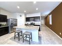Bright kitchen boasts stainless steel appliances, granite countertops, tiled floors, and a center island with seating at 4774 E Chromium Rd, San Tan Valley, AZ 85143