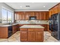 Kitchen with dark wood cabinets, tile floors, granite countertops, and black appliances at 5042 W Lariat Ln, Phoenix, AZ 85083