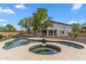 Backyard view of a dark blue pool with a hot tub, metal fence, desert landscaping, and a covered patio on the home at 5042 W Lariat Ln, Phoenix, AZ 85083