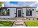 Well-maintained single-story home with landscaped front yard and traditional black and white awning at 541 W Palm Ln, Phoenix, AZ 85003