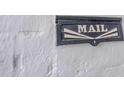 Close up of black vintage mailbox with the word MAIL emblazoned on a white brick wall at 541 W Palm Ln, Phoenix, AZ 85003