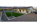 Beautiful backyard with artificial grass and desert landscaping offers a modern look with minimal upkeep at 6244 S Flora Ln, Gold Canyon, AZ 85118