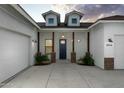 Inviting front entrance with stone pillar accents, a dark blue door, and three-car garage at 6244 S Flora Ln, Gold Canyon, AZ 85118