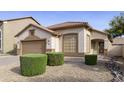 Well-maintained front yard features tidy landscaping, desert rock, and a covered entryway with a security door at 664 W Desert Basin Dr, San Tan Valley, AZ 85143
