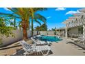 Backyard featuring a refreshing pool, lounge chairs, and desert landscaping with a palm tree at 6833 E Grandview Dr, Scottsdale, AZ 85254