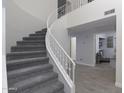 Elegant staircase with white railings and gray carpet runners leads to a light-filled landing at 9035 E Lupine Ave, Scottsdale, AZ 85260