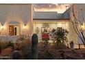 Charming home entrance features a cozy bench surrounded by desert landscape and lighting at 9827 E Fortuna Ave, Gold Canyon, AZ 85118