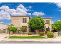 Attractive two-story home featuring desert landscaping, palm trees and a manicured lawn at 1074 E Carla Vista Ct, Gilbert, AZ 85295