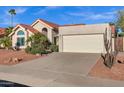 Two-car garage, desert landscaping, and charming single-story home with a red-tile roof at 10809 N 111Th Pl, Scottsdale, AZ 85259