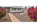 Charming home featuring a well-maintained front yard, water fountain, and gorgeous pink bougainvillea at 110 S 72Nd Way, Mesa, AZ 85208