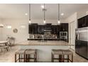 Modern kitchen with stainless steel appliances, an island, and dark cabinetry at 12031 S 184Th Ave, Goodyear, AZ 85338