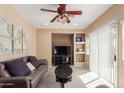 Cozy living room featuring neutral color palette, built-in shelves, and plush seating at 14239 W Port Royale Ln, Surprise, AZ 85379