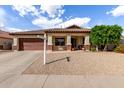 Charming single-story home featuring a two-car garage, covered porch, and low-maintenance desert landscaping at 15328 W Memory Ln, Surprise, AZ 85374
