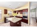 Well-equipped kitchen with stainless steel appliances, granite countertops, and dark wood cabinets at 15328 W Memory Ln, Surprise, AZ 85374