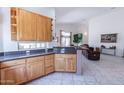 Open kitchen area with wooden cabinets and granite counters flowing into a living space with tile flooring at 1539 E Brenda Dr, Casa Grande, AZ 85122
