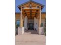 Grand entrance with a wooden overhead structure, stone pillars and black door creates an inviting welcome at 16322 E Fairview St, Gilbert, AZ 85295