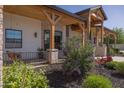 Charming covered porch showcasing timber accents, stone details and a relaxing swing for serene outdoor enjoyment at 16322 E Fairview St, Gilbert, AZ 85295