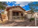 Inviting home with a cozy front porch, beautiful desert landscaping, and mature shade trees at 16424 W Cottonwood St, Surprise, AZ 85388