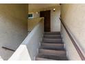 Condo entryway featuring access stairs, desert tones and a secure, decorative metal door at 1645 W Baseline W Rd # 2032, Mesa, AZ 85202