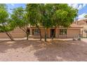 Tan single-story home with desert landscaping and mature trees, and three doors visible in the front at 1658 N Sierra Vista Dr, Tempe, AZ 85288
