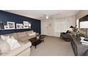 Inviting living room with neutral carpet, a blue accent wall and modern ceiling fan at 17606 N 17Th Pl # 1115, Phoenix, AZ 85022