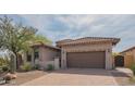 Beautiful home showcasing desert landscaping, a brick driveway, and a brown two-car garage at 1904 N Steele --, Mesa, AZ 85207