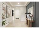 Elegant hallway featuring tile flooring, decorative lighting, and stylish wall decor at 19045 W Rose Ln, Waddell, AZ 85355