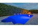 Night view of the pool with illuminated water features and a cozy fire pit, perfect for evening relaxation at 21617 S 229Th Way, Queen Creek, AZ 85142