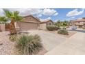 Single-story home featuring a two-car garage, desert landscaping and large driveway at 22300 N Kingston Dr, Maricopa, AZ 85138