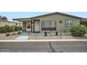 Single-story home with desert landscaping and covered patio with a seating area at 2400 E Baseline Ave # 94, Apache Junction, AZ 85119