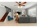 Comfortable living room featuring tile flooring, built-in shelving, and a ceiling fan at 2434 W Eugie Ave, Phoenix, AZ 85029