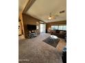 Comfortable living room with neutral carpet, television, and bright natural light at 2661 N Wright Way, Mesa, AZ 85215